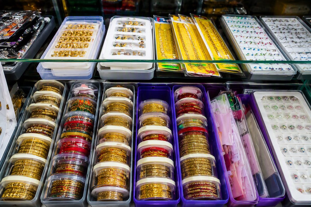 Display case with gold-tone bangles, rings and jewellery sets
